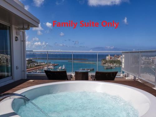 a bath tub with a view of the ocean at Seaside Condominium Rana Chatan in Chatan