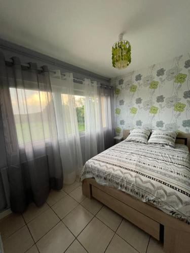 une chambre avec un lit et une fenêtre dans l'établissement Appartement RDC avec terrasse, à Sainte-Mère-Église