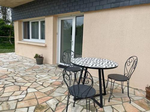 une table et des chaises assises sur une terrasse dans l'établissement Appartement RDC avec terrasse, à Sainte-Mère-Église