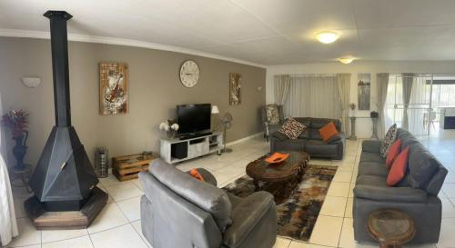 a living room with a couch and a fireplace at Rustic red in Benoni