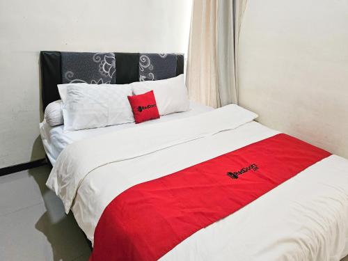 Ένα ή περισσότερα κρεβάτια σε δωμάτιο στο RedDoorz Syariah Nanna Homestay Near Dino Park