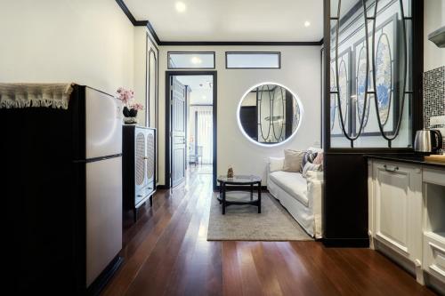 a living room with a white couch and a mirror at BAAN 125 STAY Phuket in Phuket Town