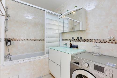 La salle de bains est pourvue d'un lave-linge et d'une douche. dans l'établissement À 1 minute du métro et Parking privé, à Paris