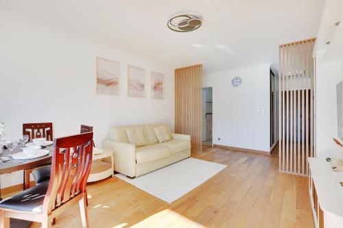 un salon avec une table et un canapé dans l'établissement À 1 minute du métro et Parking privé, à Paris