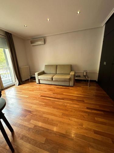 a living room with a couch and a wooden floor at Hotel Hita "Nature Experience" for all in Navacerrada