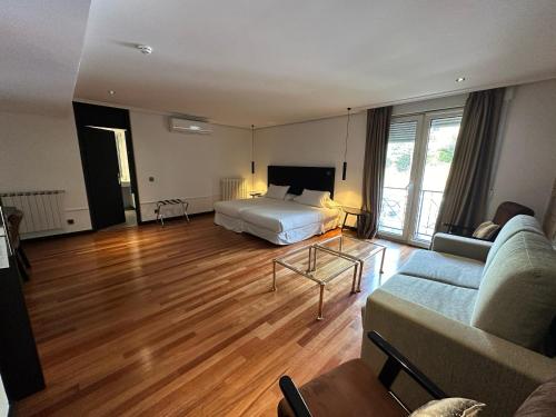 a living room with a bed and a couch at Hotel Hita "Nature Experience" for all in Navacerrada