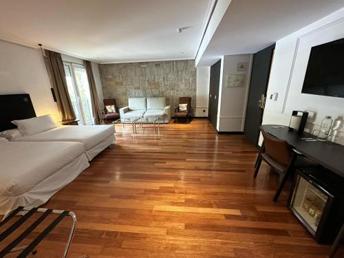 a hotel room with a bed and a living room at Hotel Hita "Nature Experience" for all in Navacerrada