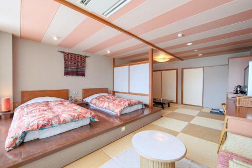 a bedroom with two beds and a table at Yuzawa Grand Hotel in Yuzawa