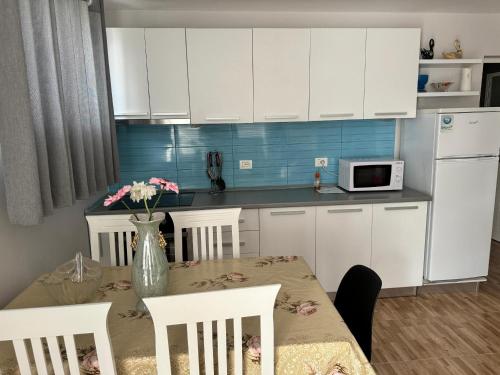 a kitchen with a table with a vase of flowers on it at Villa Kei in Tirana