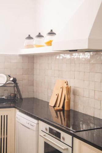 a kitchen with a black counter top with utensils at CASA SIRA-Charming home in the heart of the Kasbah in Tangier