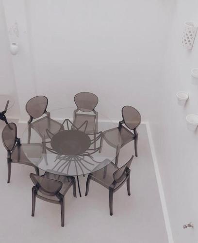 a glass table with four chairs around it at CASA SIRA-Charming home in the heart of the Kasbah in Tangier