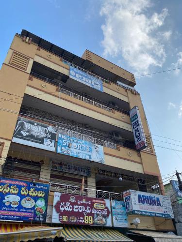 a tall building with signs on the side of it at Swamy's Aruna Residency in Chīrāla