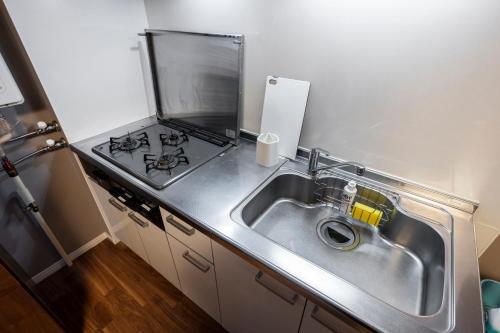 a kitchen with a sink and a stove at Venture in Ōdōri
