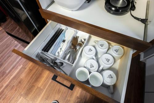 a drawer in a counter with cups and utensils at Venture in Ōdōri