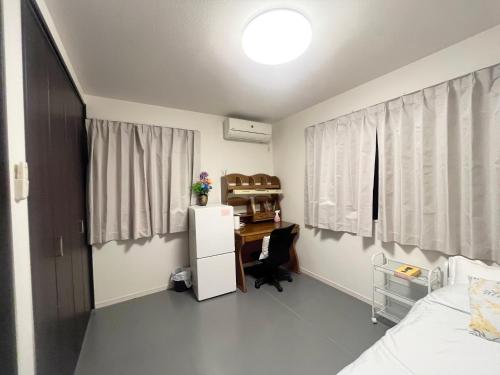 a bedroom with a desk and a bedroom with a bed at 花乃郷 北小岩 in Tokyo