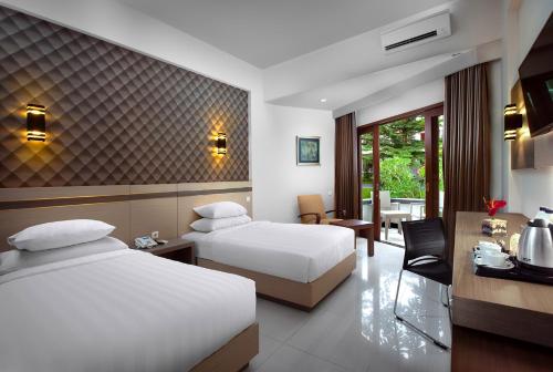 Postel nebo postele na pokoji v ubytování Lombok Raya Hotel