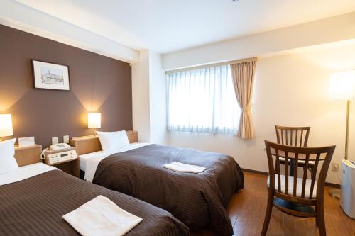 une chambre d'hôtel avec deux lits et une fenêtre dans l'établissement Sapporo Clark Hotel, à Sapporo