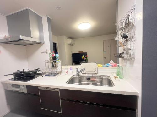 a kitchen with a sink and a stove at 花乃郷 北小岩 in Tokyo