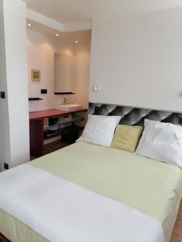 une chambre avec un lit, un bureau et un lavabo dans l'établissement Bel hébergement, au Havre
