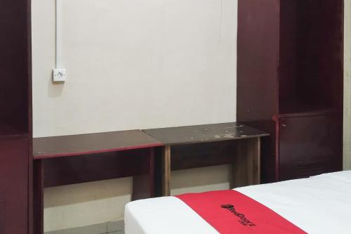 a desk in a room with a bed at RedDoorz at Ameria Bandara Nongsa Batam in Hang Nadim International Airport