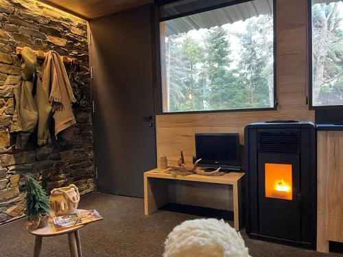 Cette chambre dispose d'une cheminée et d'un bureau avec un ordinateur. dans l'établissement refugio en el bosque, à La Molina