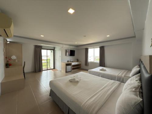 ノンタブリーにあるRegent Ngamwongwan Hotelのベッド2台とリビングルームがあるホテルの部屋