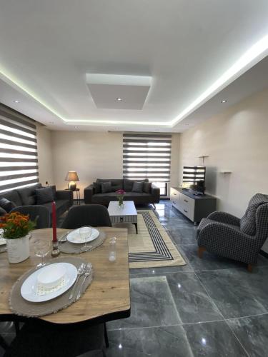 a living room with couches and a table and chairs at Alis Home Pamukkale in Pamukkale