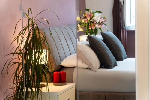 Una sala de estar con un sofá con almohadas y una planta. en C&Y Apartments - Roma Vaticano St Peter - Luxe Penthouse Flat, en Roma