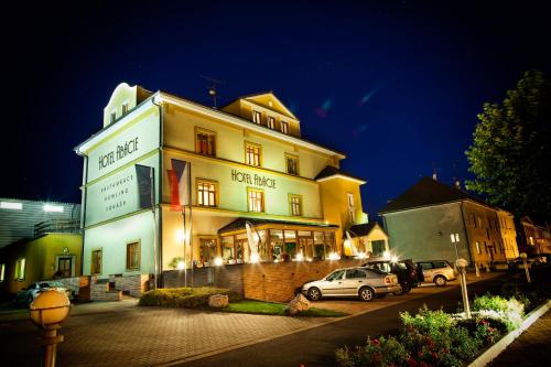 a large building with cars parked in front of it at Hotel Abácie & Wellness in Valašské Meziříčí