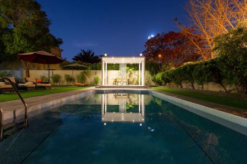 a swimming pool in a backyard at night at Private villa in Dubai with swimming pool and huge garden in Dubai