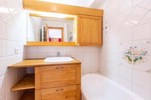 une salle de bain avec un lavabo, un miroir et une baignoire dans l'établissement Résidence Alpages D - ALPAGES D002 MAE-6331, à Les Allues