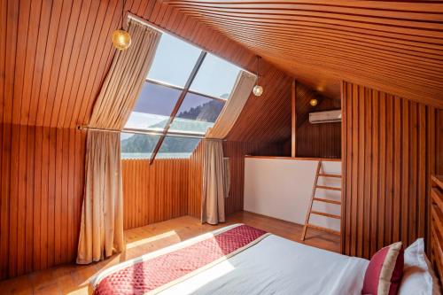 a bedroom with a bed and a large window at WOW STAYZ2 Ashoka Grand in Dalhousie