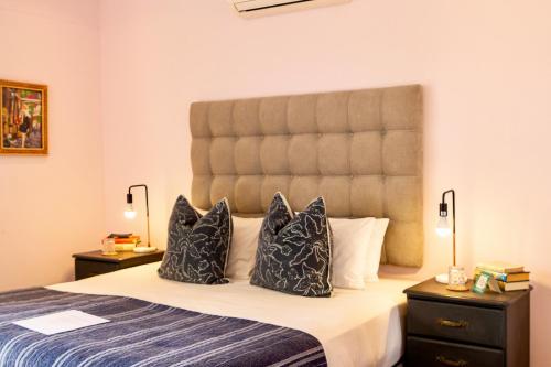 a bedroom with a large bed with two pillows at Royal Boutique Hotel in Cape Town