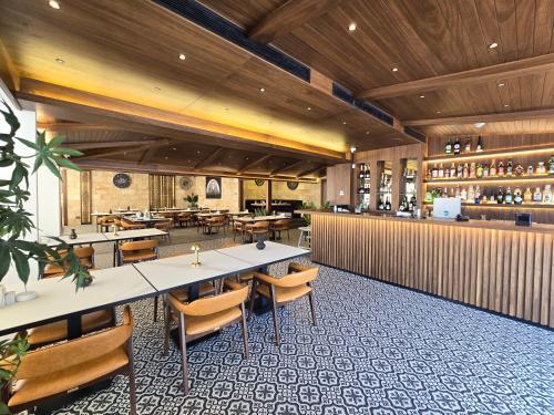 a restaurant with tables and chairs and a bar at Maximus Hotel Byblos in Jbeil