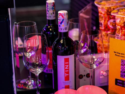 a group of wine bottles and glasses on a table at Cupid Hotel in Ho Chi Minh City