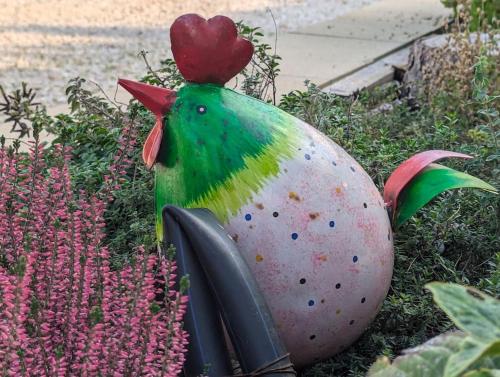 a statue of a chicken sitting in the grass at Domus MEA - Breakfast Included! in San Martino Buon Albergo