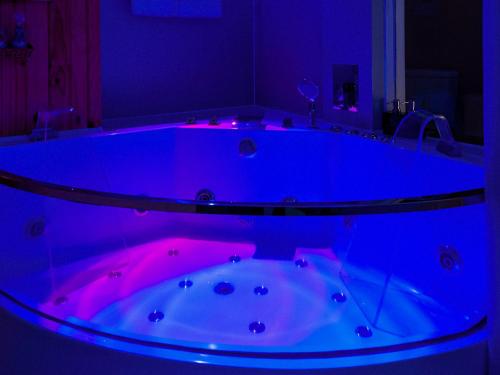 a bathroom with a tub with purple lights in it at Cupid Hotel in Ho Chi Minh City