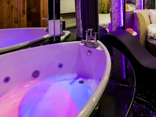 a bath tub with purple lighting in a bathroom at Cupid Hotel in Ho Chi Minh City