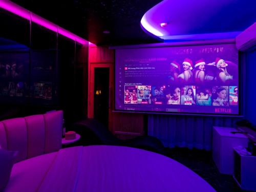 a room with a large screen with purple lights at Cupid Hotel in Ho Chi Minh City