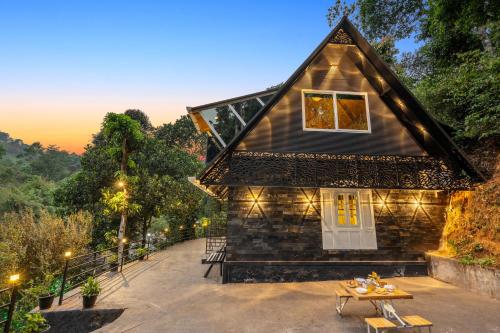 a house with a table in front of it at The Cove Lakkidi in Vythiri