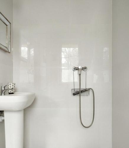 a white bathroom with a sink and a shower at Ulęgałki Roztocze Stodoła in Jacnia