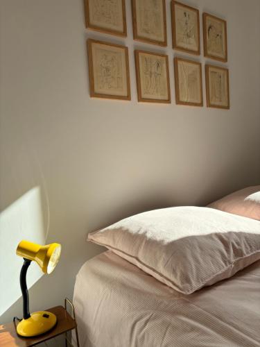 a yellow lamp on a table next to a bed at Raphaël - T2 centre historique in Le Puy en Velay