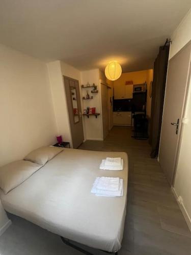 une chambre avec un lit blanc avec deux serviettes dessus dans l'établissement Studio Distillerie, à Narbonne