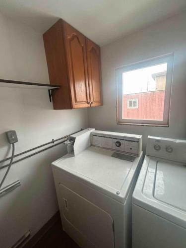a kitchen with a washing machine and a window at Kings Studio Apartment A in Nome