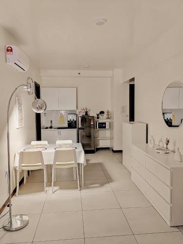 a white kitchen with a table and white chairs at K Avenue Kota Kinabalu in Donggongon