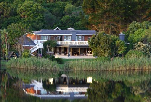 a house on the shore of a body of water at Serendipity Country House & Restaurant in Wilderness