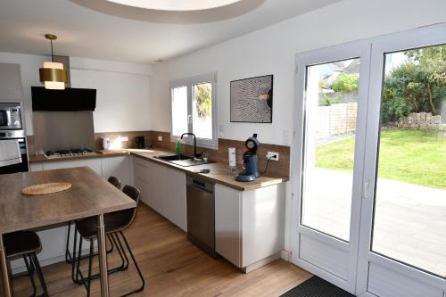 une cuisine avec un comptoir et une table avec des chaises dans l'établissement maison spacieuse et au calme, à Brest