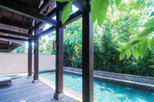 a swimming pool outside of a house with trees at Narada Resort & Spa Perfume Bay Sanya - All Villas in Lingshui