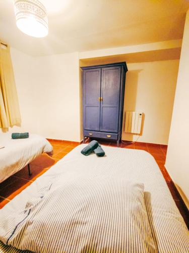 a room with two beds and a blue cabinet at Cortijo Rural El Contador, con chimenea in Constantina