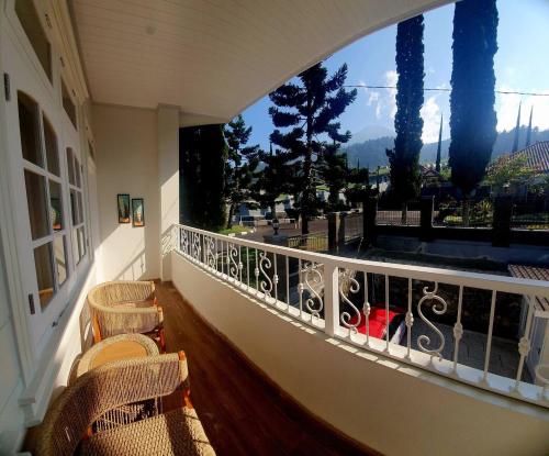 a balcony with chairs and a view of the mountains at Villa amira syariah in Tawangmangu